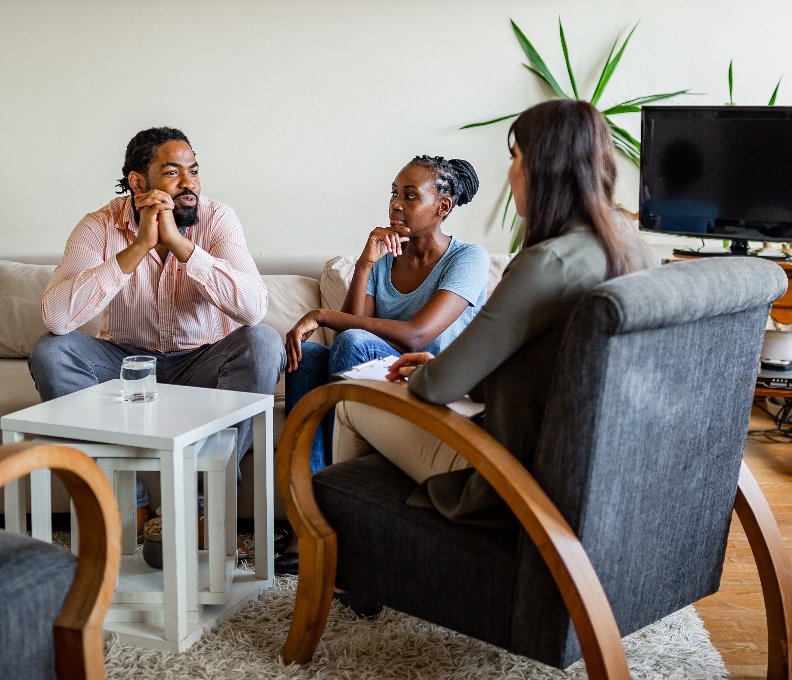 A solicitor sits with a couple discussing their Will